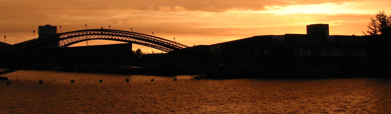 De rode brug over het IJ bij zonsondergang